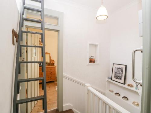 a ladder leading up to a hallway with a stair case at 7 Bell Street in Talgarth