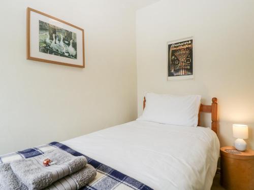 a small bedroom with a bed and a picture on the wall at 7 Bell Street in Talgarth