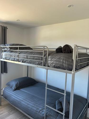 two bunk beds in a room with a bed at A new built brick chalet in Leysdown-on-Sea