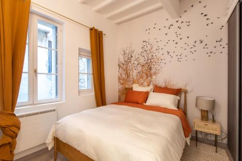a bedroom with a bed with birds on the wall at Hirondelle de Montpellier in Montpellier