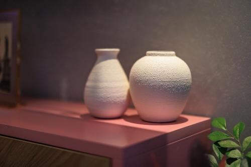 two white vases are sitting on a shelf at Rosetti One in Constanţa