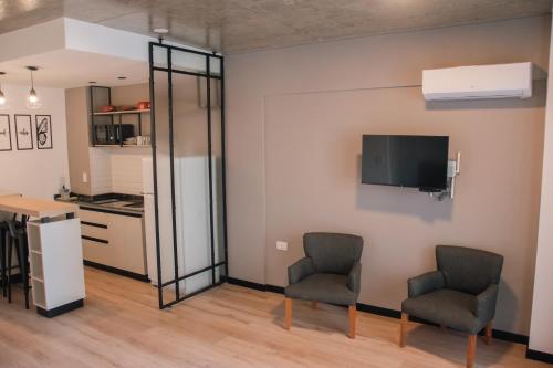a living room with two chairs and a kitchen at Distrito A FMA-Coliving in Salta
