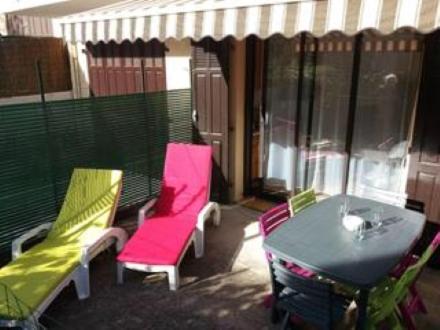 - une terrasse couverte avec 2 chaises et une table sur un balcon dans l'établissement Charmant T2, quartier résidentiel calme, St Aygulf, à Fréjus