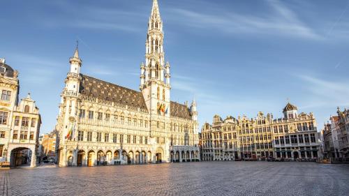 a large building with a clock tower in a city at voco Brussels City North by IHG in Vilvoorde