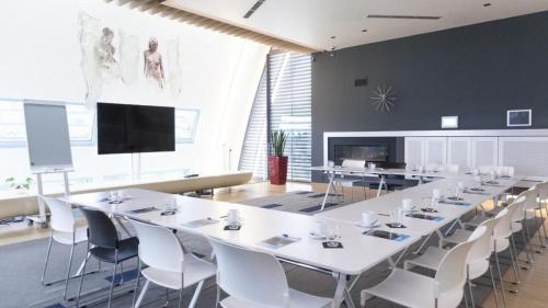 a large conference room with white tables and chairs at voco Brussels City North by IHG in Vilvoorde