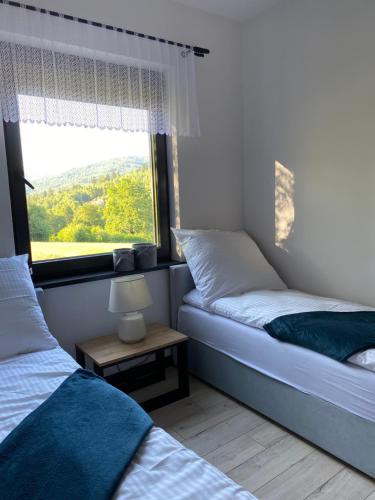 1 Schlafzimmer mit 2 Einzelbetten und einem Fenster in der Unterkunft DOMKI MADZIA in Brenna