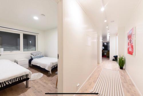 トロムソにあるAurora and midnight sunの白い壁のベッドルーム1室(ベッド1台、窓付)