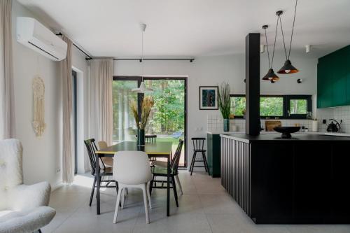 - une cuisine et une salle à manger avec une table et des chaises dans l'établissement Domek z basenem nad Bugiem, 