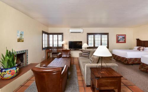 a living room with a bed a couch and a fireplace at Lodge On The Desert in Tucson