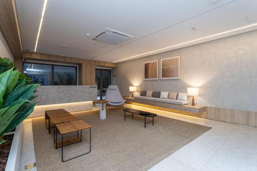 uma sala de estar com um sofá e mesas em Apartamentos novos ao lado do MASP e a metros da paulista - Next Haddock em São Paulo