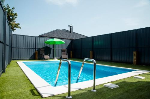 a swimming pool with a fence and an umbrella at MILUX in Sanski most