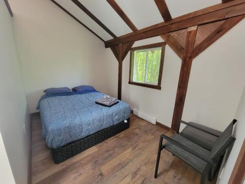 1 dormitorio con 1 cama y 1 silla en Noah's Ark Campground, en Revelstoke