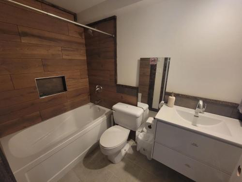 a bathroom with a toilet and a tub and a sink at Noah's Ark Campground in Revelstoke