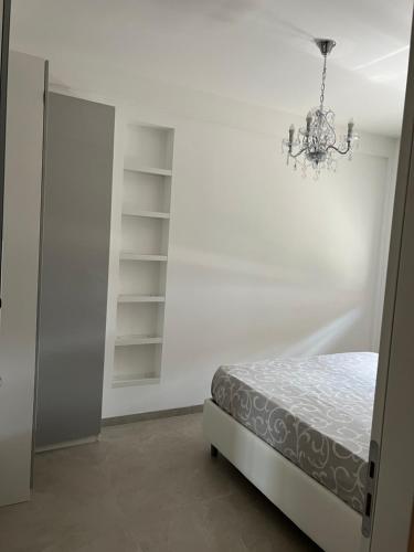 - une chambre avec un lit et un lustre dans l'établissement Maison Chic Montenero Marina, à Marina di Montenero