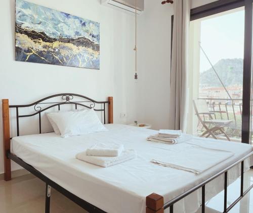 a bedroom with a bed with two towels on it at Zanteapts 360 Gouzeli Apartment in Zakynthos Town