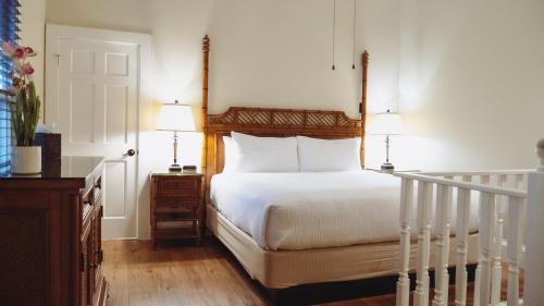 La Pensione Inn - Adult Exclusive في كي ويست: غرفة نوم بسرير مع مصباحين ودرج