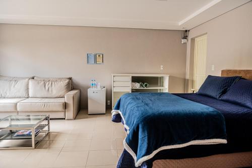 a living room with a bed and a couch at FIKA Residence in Dois Irmãos