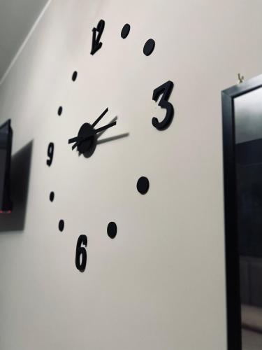 a clock on a white wall with black dots at Akropoli Exclusive Room in Agrigento