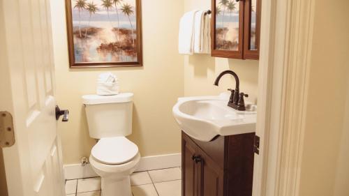 a bathroom with a toilet and a sink at La Pensione Inn - Adult Exclusive in Key West
