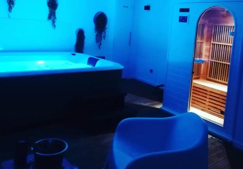 Habitación azul con bañera y silla en Maison sud de France avec jacuzzi et sauna privé, en Villeneuve-lès-Maguelonne