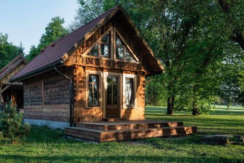 a small log cabin in the grass at Siedlisko Szaciłówka - Domek Lipowy in Krynki