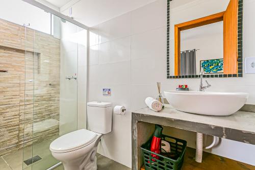 une salle de bain avec un lavabo, des toilettes et un miroir dans l'établissement Flats das Palmeiras, à Florianópolis