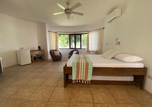1 dormitorio con 1 cama y ventilador de techo en Casa Iola en Cancún
