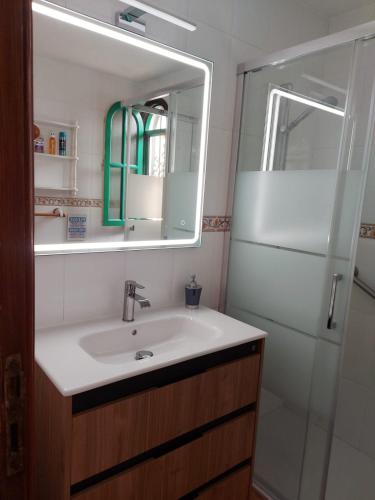 a bathroom with a sink and a mirror and a shower at Sunny Villa Maspalomas in Maspalomas