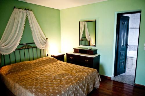 a bedroom with a bed and a mirror at Vasilaras Hotel in Skala