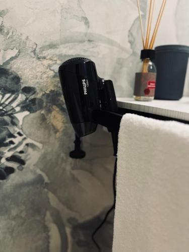 a black hair dryer sitting next to a towel at Akropoli Exclusive Room in Agrigento