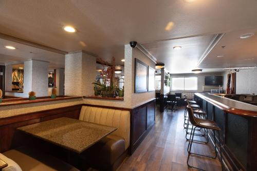 a bar in a restaurant with chairs and a counter at Oxnard Inn Lancaster in Lancaster
