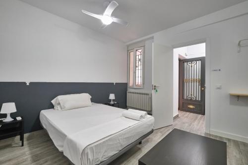 1 dormitorio con 1 cama y ventilador de techo en Núñez de Arce habitaciones, en Madrid