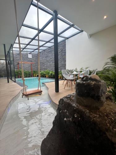a house with a swimming pool with a swing at Springhills Quito Airport in Tababela