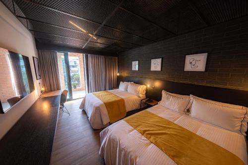 a hotel room with two beds and a window at FULTON Business Luxury HOTEL in Guadalajara