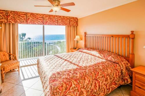 a bedroom with a bed and a large window at Sand Pebble Resort in St Pete Beach