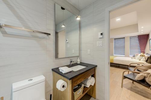 a bathroom with a sink and a toilet and a bed at 77 St-Vallier in Quebec City