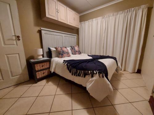 a bedroom with a bed and a window at Private Apartment for business and leisure Pretoria East in Pretoria