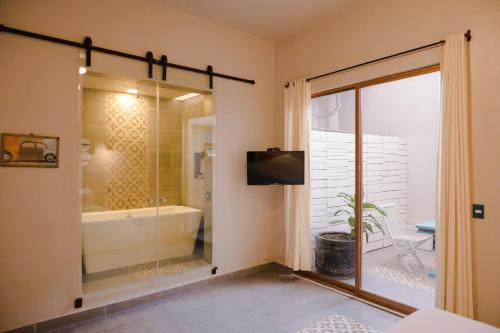 ein Bad mit einer Badewanne, einem TV und einer Dusche in der Unterkunft Hotel Del Portal San Miguel de Allende in San Miguel de Allende