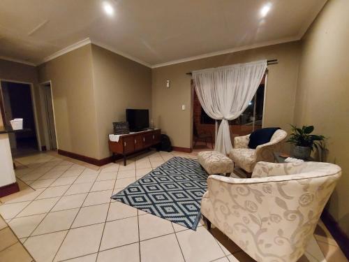 a living room with a couch and a tv at Private Apartment for business and leisure Pretoria East in Pretoria