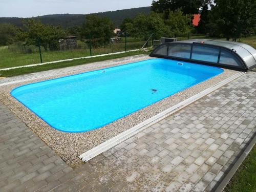 un coche aparcado junto a una piscina azul en Vila v Brdech s bazénem, infra saunou a vybavením, 