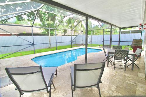 a patio with chairs and a pool in a house at Jupiter Sunshine in Jupiter