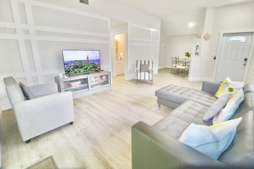 a living room with a couch and a flat screen tv at Jupiter Sunshine in Jupiter