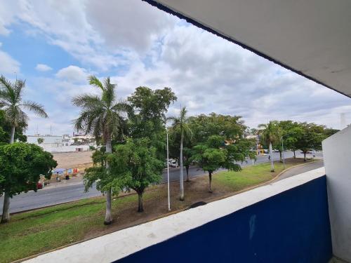 una ventana con vistas a una calle con palmeras en Hotel TorreBlanca, en Culiacán