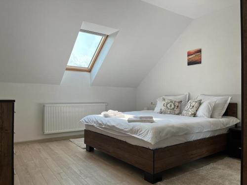 - une chambre avec un grand lit et une fenêtre dans l'établissement Sabina Apartaments, à Sfântu-Gheorghe