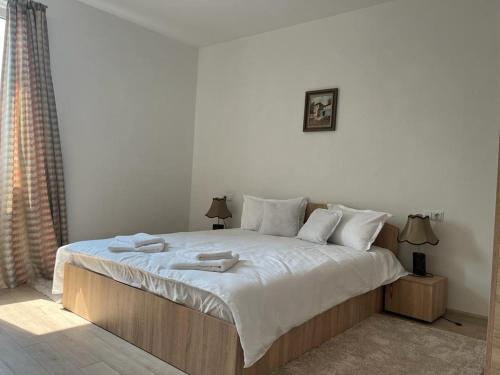 a bedroom with a bed with two towels on it at Sabina Apartaments in Sfântu-Gheorghe