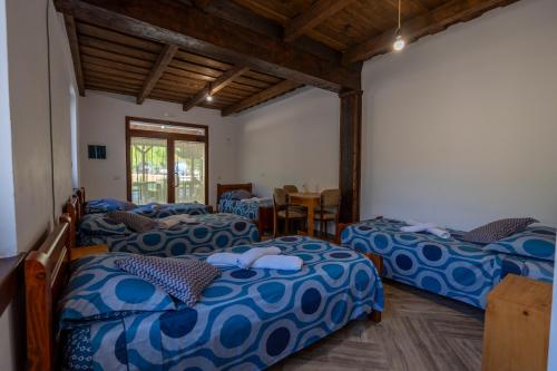 um quarto com três camas e uma mesa em Guesthouse Véni i Gjyshit em Shkodër