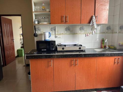 a kitchen with wooden cabinets and a counter top at Oak Cottage in Dar es Salaam