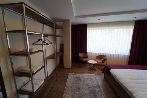 a hotel room with a bed and a book shelf at Monarch Hotel in Prizren