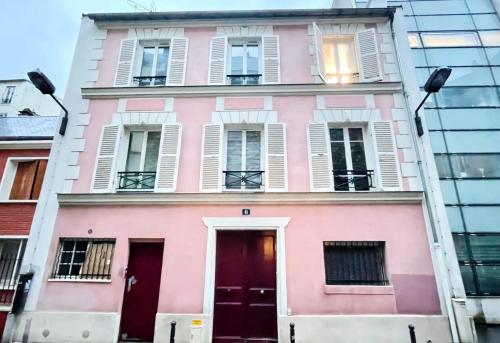 un bâtiment rose avec des fenêtres et une porte dans l'établissement Pink Warm Studio near Arc de Triomphe, à Paris