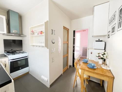 Il comprend une petite cuisine avec une table en bois et une petite salle à manger. dans l'établissement Pink Warm Studio near Arc de Triomphe, à Paris